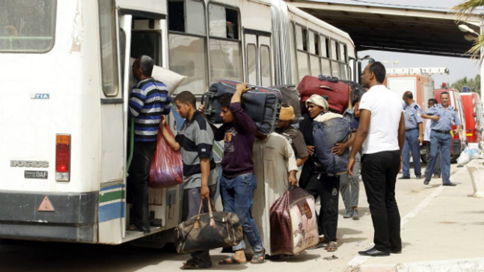 Lybische Flüchtlinge besteigen einen Bus in Ben Ghardane in Tunesien.