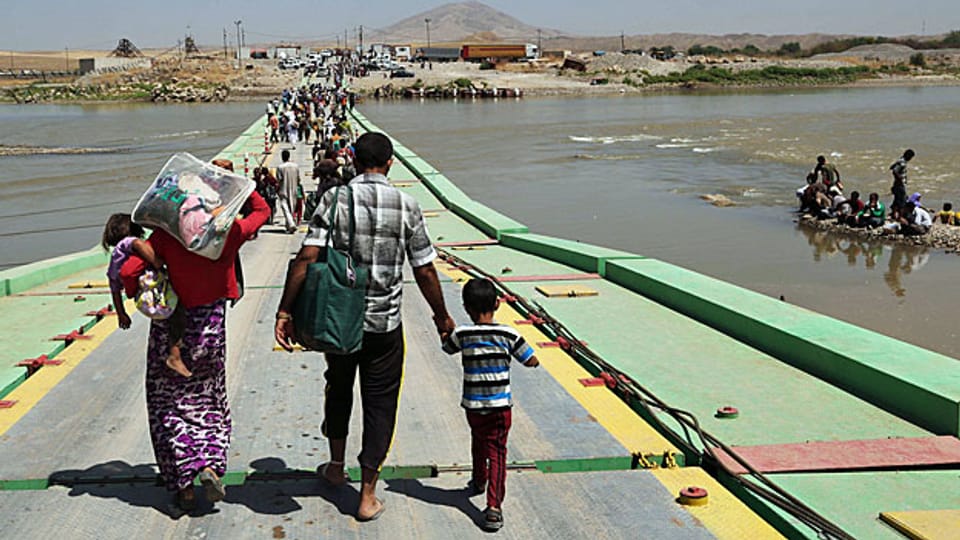 Eine jesidische Familie überquert am 10. August die irakisch-syrische Grenze über den Tigris. Die meisten Grenzen wurden im Nahen Osten während der Kolonialzeit festgelegt.