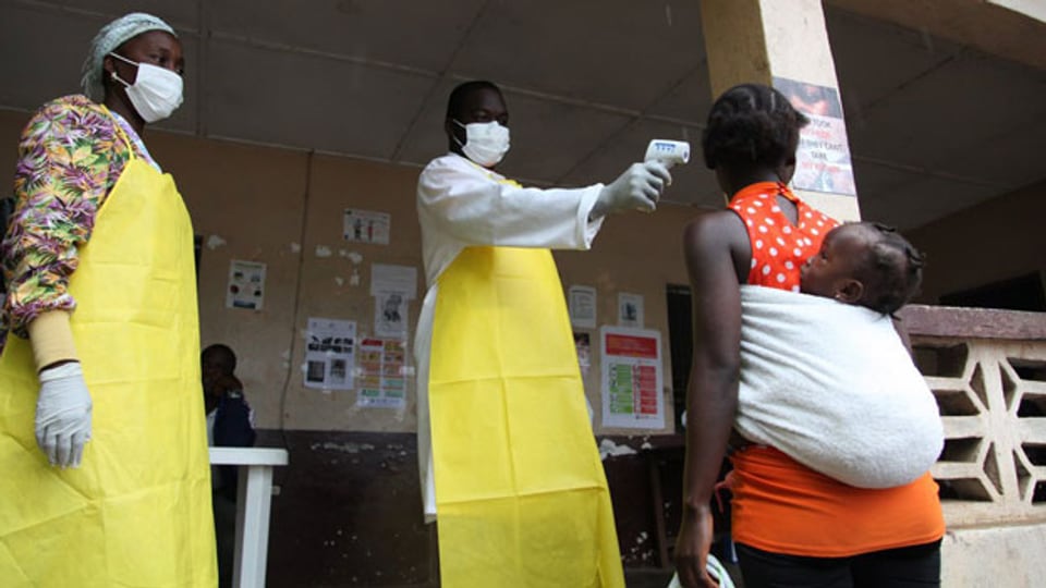 Eine liberianische Krankenschwester misst die Temperatur einer Liberianerin in Bomi County, Liberia.
