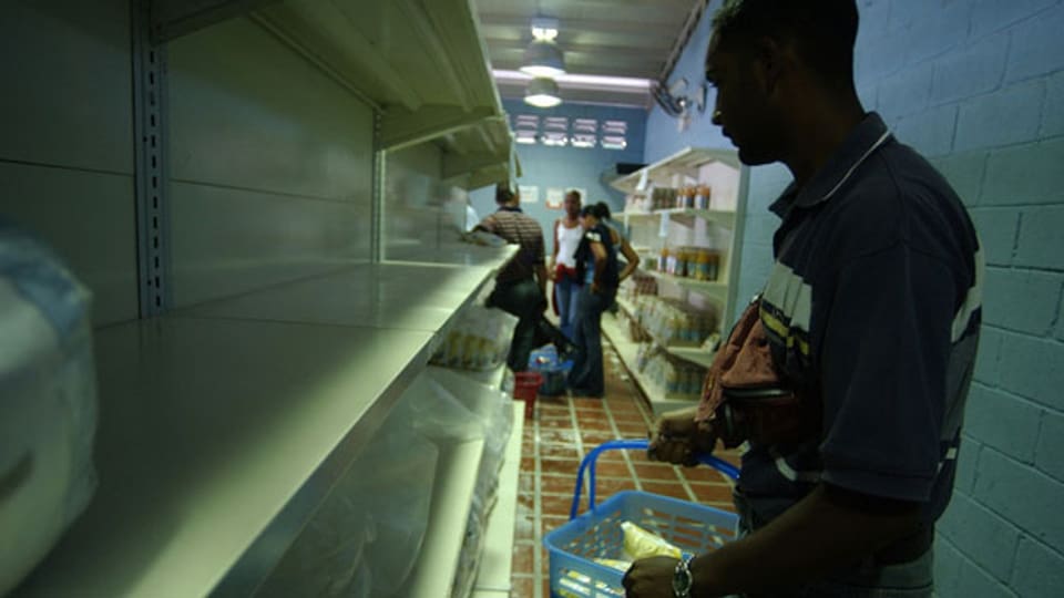 Ein Mann macht Einkäufe in einem Supermarkt in einem Armenviertel in Caracas, Venezuela. Die Versorgungslage ist prekär.