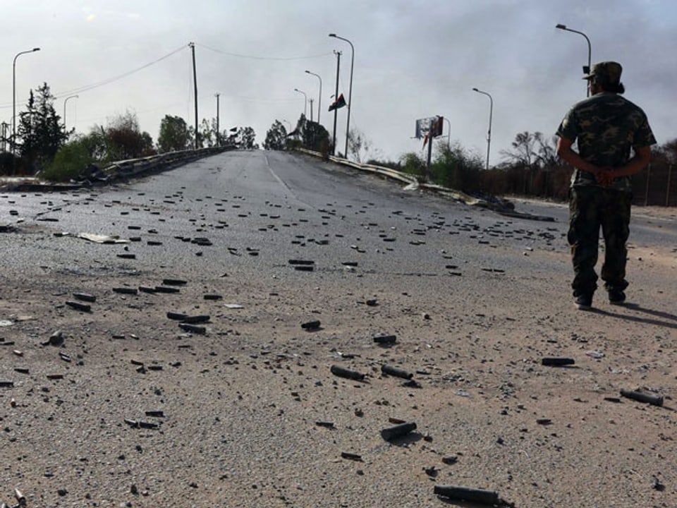 Misrata-Rebell schrietet über Patronenhülsen auf dem Flughafenarea