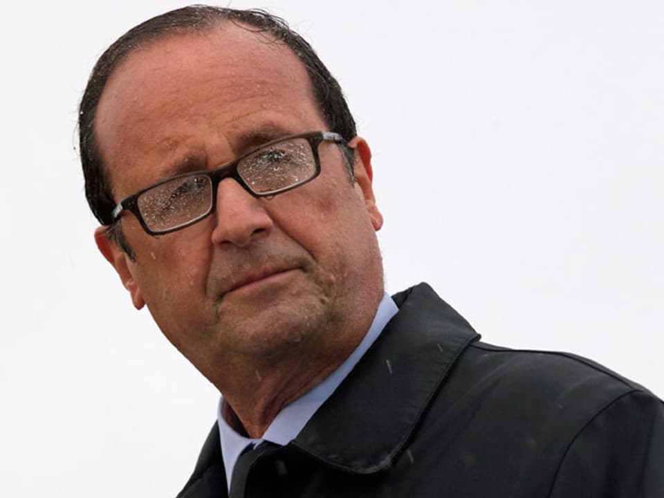 Frankreichs Präsident François Hollande steht im Regen.