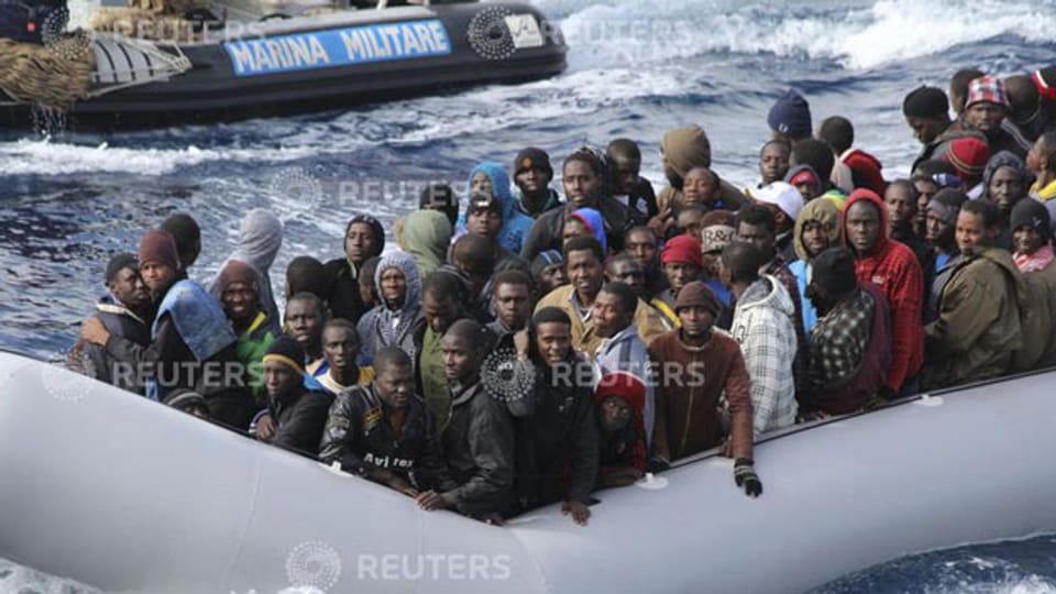 Migranten in einem Boot vor der italienischen Insel Sizilien.