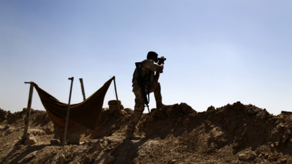Ein Peschmerga sucht mit einem Feldstecher nach IS-Truppen in der Nähe von Makhmour.