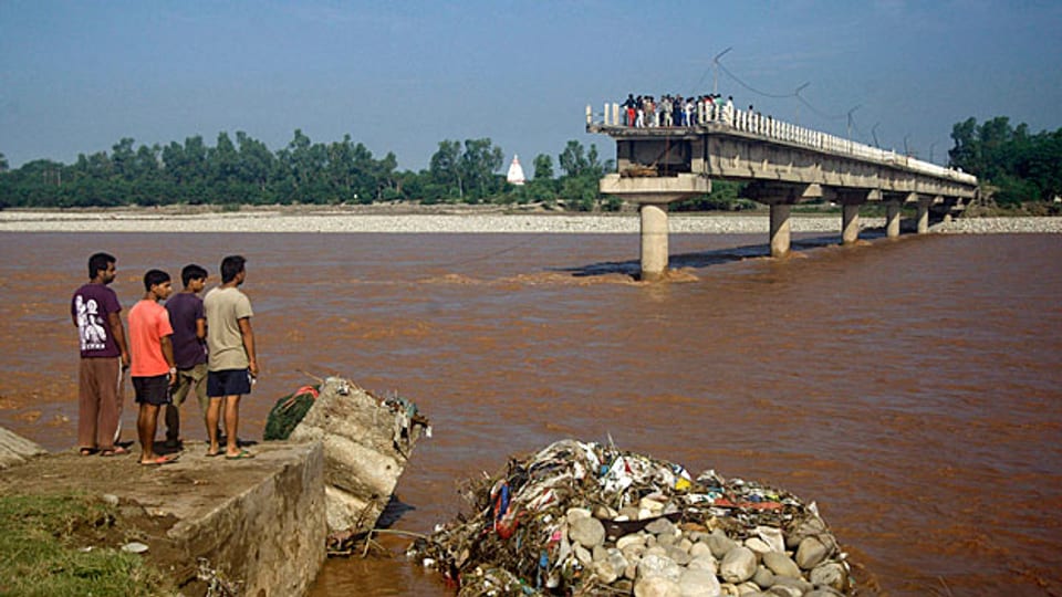Eine Brücke über den Fluss Tawi im Norden Indiens ist zur Hälfte von den Fluten mitgerissen worden.