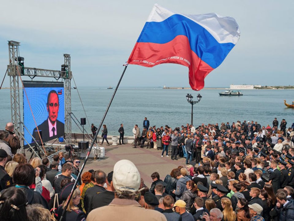 Gebannt blickt die Menschenmenge auf die Übertragung einer Rede Putins in Sewastopol