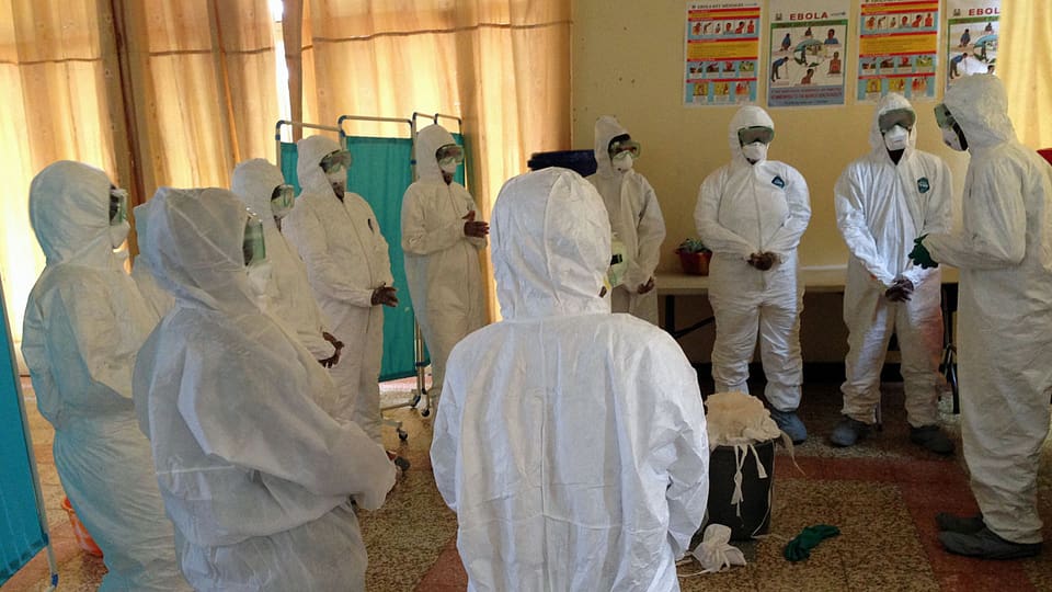 Freiwillige HelferInnen werden darüber informiert, wie sie sich am besten gegen eine Ansteckung mit dem Ebola-Virus schützen können.