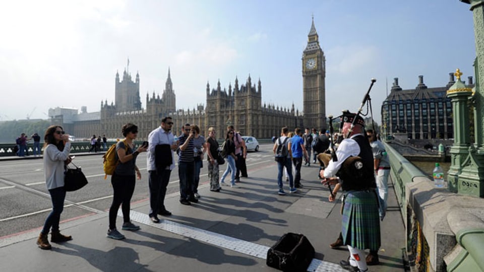 Schottland hat beschlossen, ein Teil des Vereinigten Königreichs zu bleiben. Dudelsackspieler auf der Westminster Bridge, vor dem House of Parliament mit Big in London am 19. September 2014.