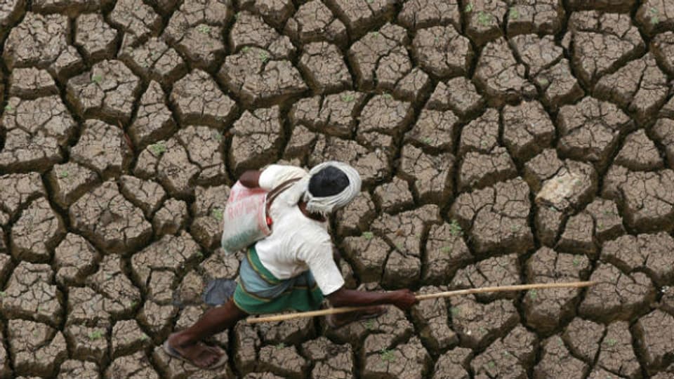 Ein Landwirt auf ausgetrocknetem Land in Hyderabad im Süden Indiens.