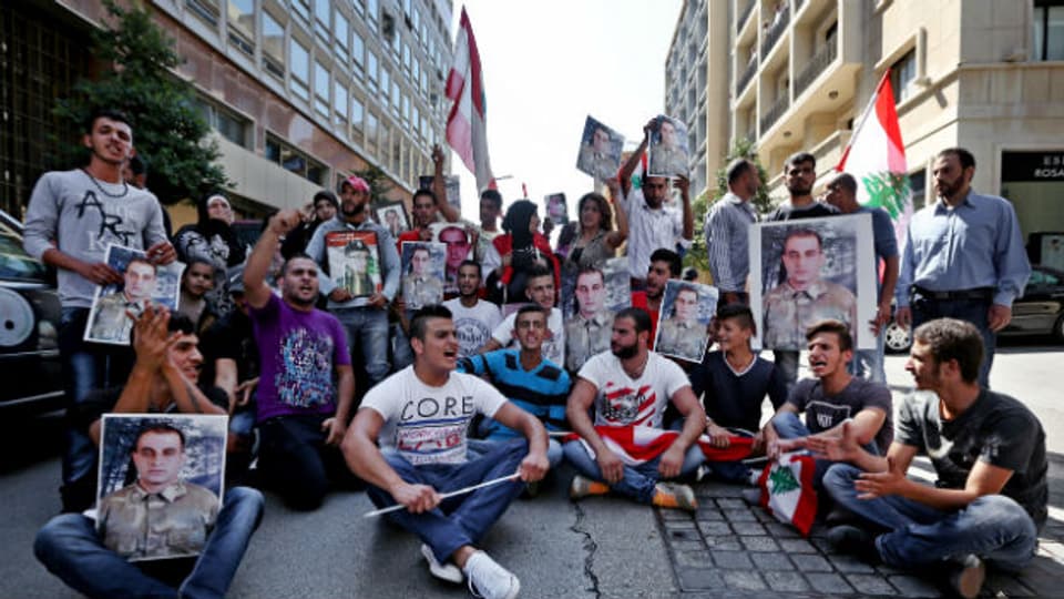 LibanesInnen sitzen in Beirut am Boden und machen auf von der Terrorgruppe Islamischer Staat gekidnappte Soldaten aufmerksam.