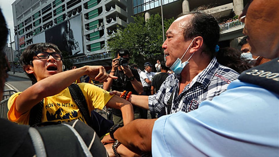 Ein Mitglied der Demokratiebewegung wird von einem Mann angegriffen, der mit den Zielen der «Occupy Central»-Bewegung nicht einverstanden ist.