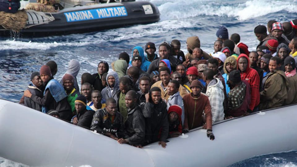 Migranten in einem Boot während einer Rettungsaktion von der italienischen Marine vor der Küste vor der Insel Sizilien.