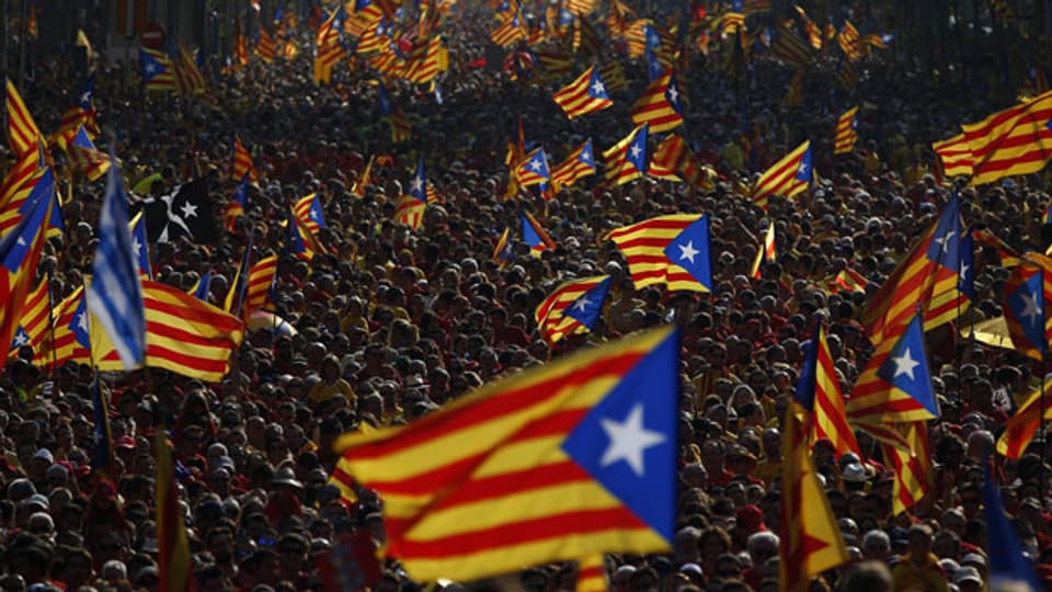 Fahnenschwenkende Demonstranten kämpfen für Kataloniens Unabhängigkeit.