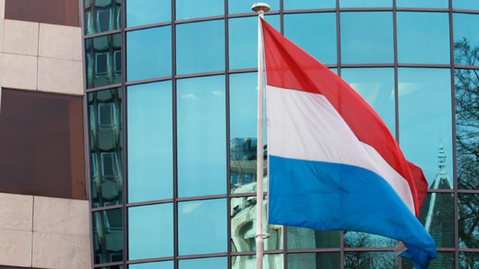 Die Luxemburgische Nationalflagge vor dem Hauptsitz der Bank von Luxemburg.