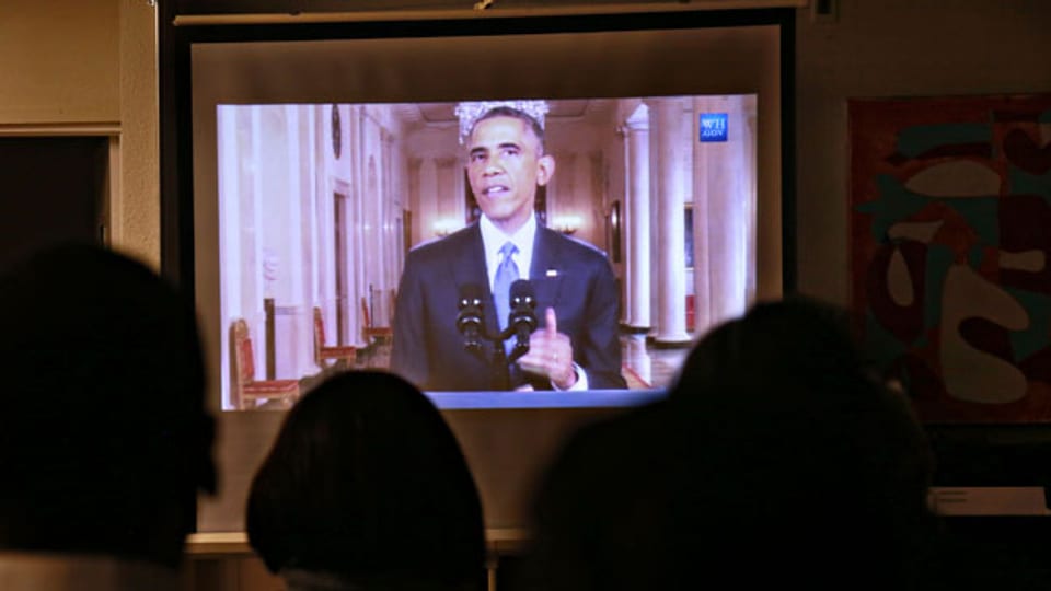 Eine Gruppe von Einwanderern verfolgt Obamas Rede am Fernsehen.