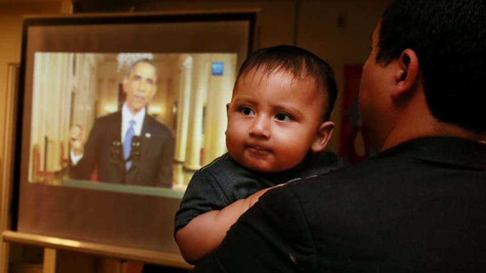 Christian Ramirez mit seinem neun Monate alten Sohn Diego, während  der amerikanische Präsident den Abschiebe-Stopp für Millionen illegaler Einwanderer verkündet.