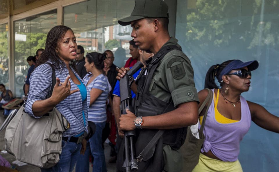 Kundinnen in Caracas beschweren sich bei Nationalgarde über lange Schlangen vor einem Supermarkt