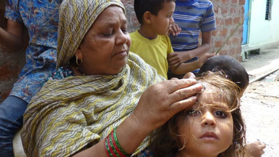 Im kleinen Attal Ayub Slum laust Zora Bi ihr Enkelkind. Ihre 2-jährige Nichte starb im Chemie-Unfall und als sie eineinhalb Jahre später selbst ein Kind gebar, habe das erst nach drei Jahren die Augen geöffnet.