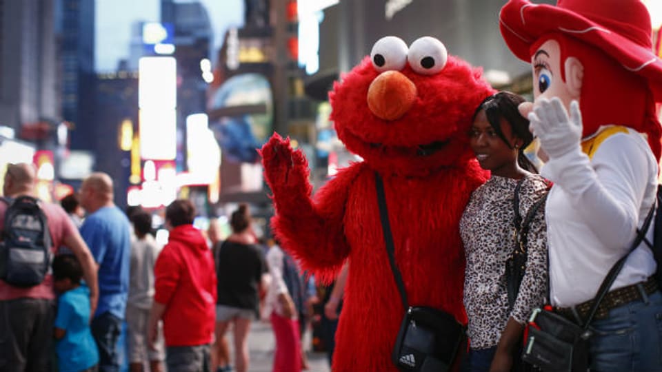 Times Square in New York: Eine Touristin posiert mit einer als Elmo verkleideten Figur.