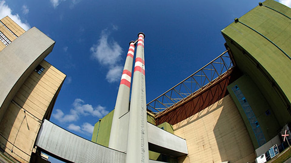 Atomkraftwerk Paks. An einer weiten Schleife der Donau stehen vier riesige Reaktorgebäude,  dazwischen zwei mal zwei schmale hohe Kamine. Bild: Der Reaktor Nummer 4.