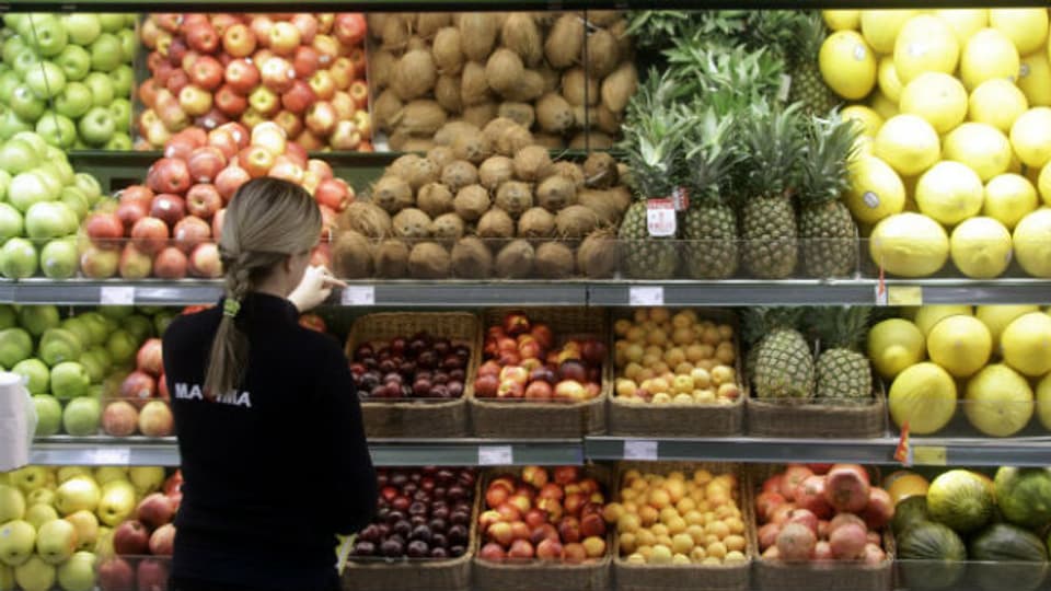 Eine Angestellte im Supermarkt tauscht Preisschilder aus.