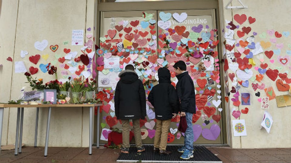 Drei Knaben lesen Unterstützungs-Bekundungen für Muslime beim Eingang der Moschee in Uppsala.