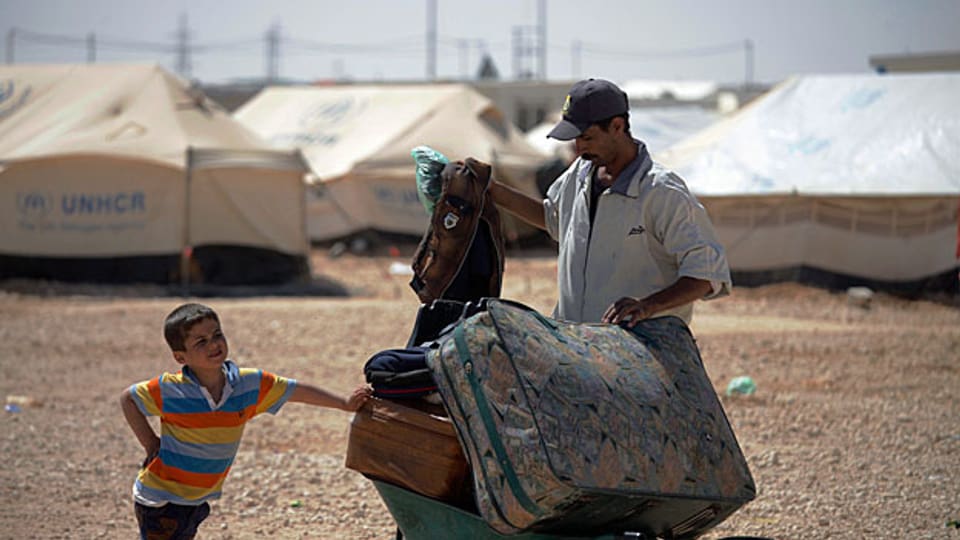 Flüchtlinge aus Syrien vor einem Lager an der jordanisch-syrischen Grenze.