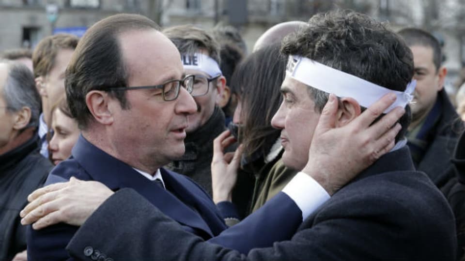 Präsident Hollande tröstet Patrick Pelloux vom Satiremagazin Charlie Hebdo.