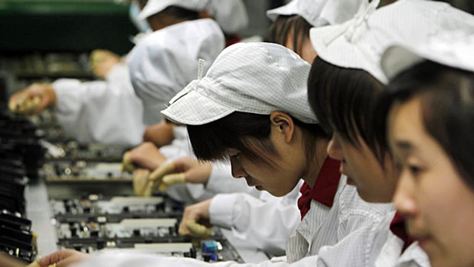 Chinesische Arbeiterinnen in einem IT-Produktionsunternehmen. Peking will in Zukunft hin zu einer werthaltigeren Produktion.