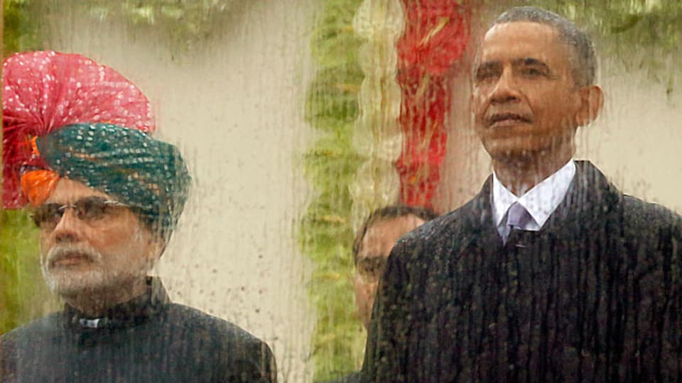 An der Parade zum indischen Tag der Republik – hinter einer Glasscheibe an die der Regen prasselt: der indische Premier Narendra Modi und sein Ehrengast, US-Präsident Barack Obama.