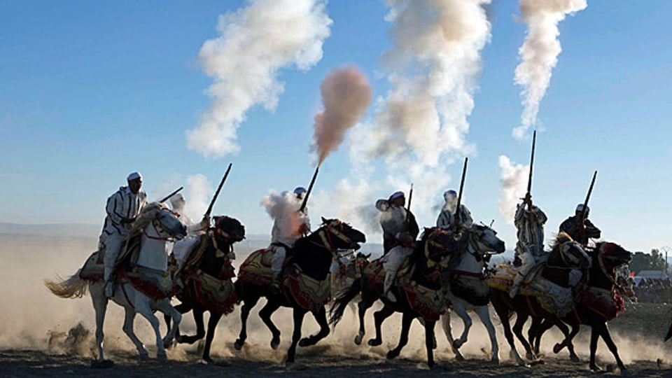 Ein halbes Dutzend Männer in traditionellen Gewändern auf Pferden feiern den Jahrestag der marokkanischen «Marche Verte» im Jahr 1975.