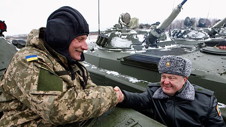 Der ukrainische Präsident Petro Poroschenko grüsst einen Panzersoldaten. – anlässlich einer Zeremonie zur Übergabe neuer Armeeausrüstungsgegenstände wie POanzer und Waffen. Anfangs Januar im Norden der Ukraine.
