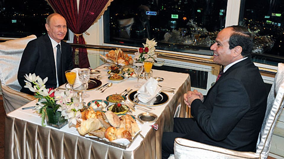Blumen und ein reich gedeckter Tisch. Gastgeber al-Sisi lächelt Wladimir Putin zu.