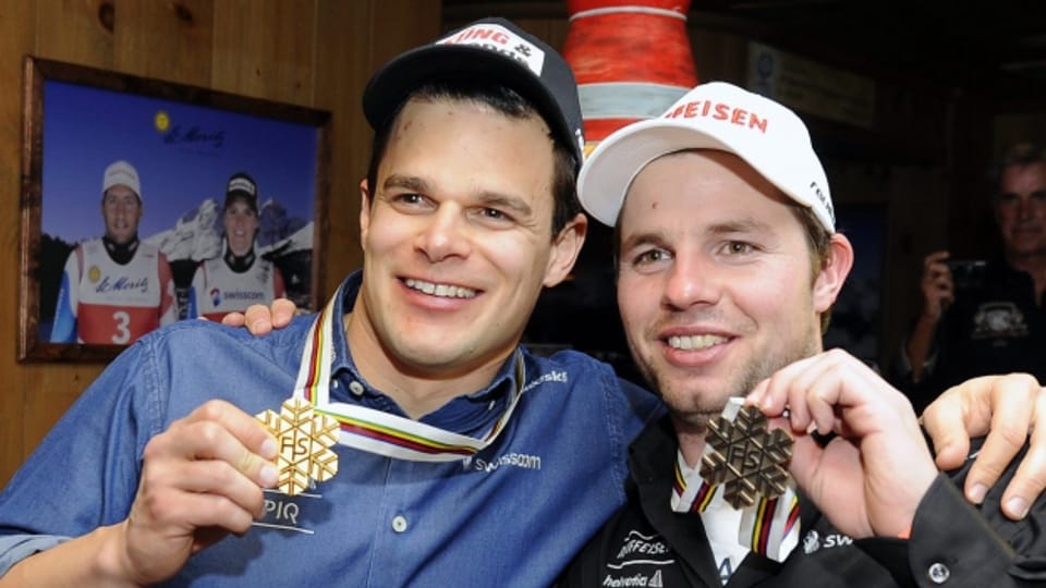 Die Schweizer Skirennläufer Patrick Küng und Beat Feuz feiern ihre Medaillen