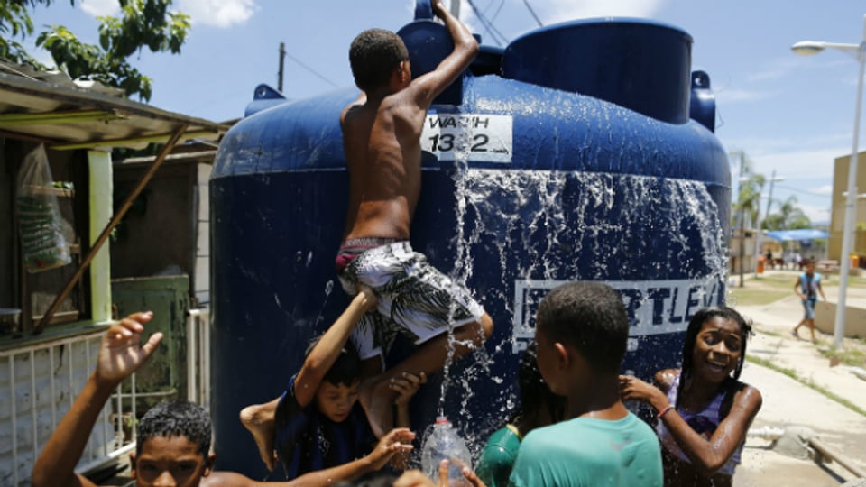 Kinder in Sao Paulo kühlen sich unter einem Wassertank ab.