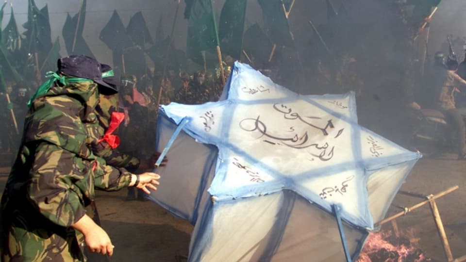Radikale Palästinenser verbrennen eine Israel-Flagge.