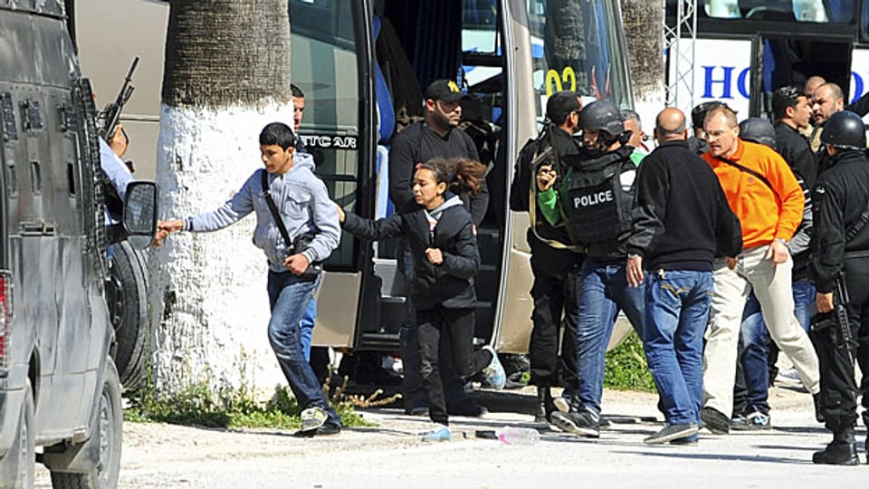 Sicherheitskräfte begleiten Besucherinnen und Besucher des Baro-Nationalmuseums in Tunis  aus der Gefahrenzone.
