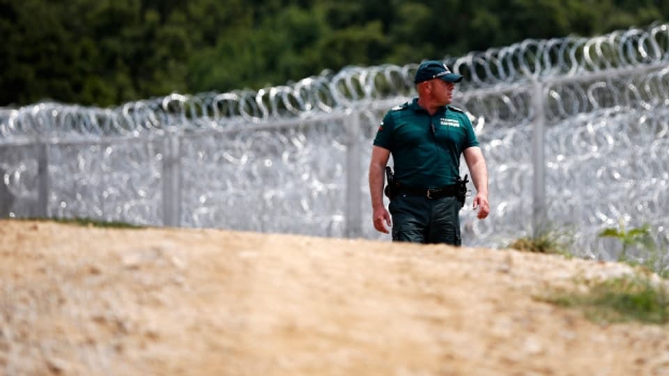 Ein bulgarischer Grenz-Polizist kontrolliert die bulgarisch-türkische Grenze vor dem hochmodernen Stacheldrahtzaun.