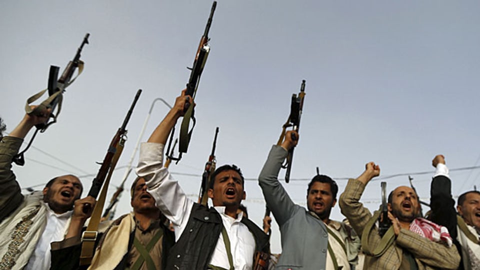 Bewaffnete Anhänger der Huthi mit erhobenen Waffen - nach einem Angriff der saudischen Luftwaffe in der jemenitischen Hauptstadt Sanaa.