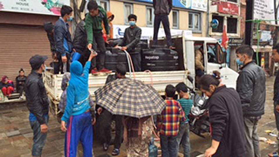 Freiwillige Helfer verteilen Hilfsgüter von einem Lastwafen - in einer Strasse der nepalesischen Hauptstadt Kathmandu.