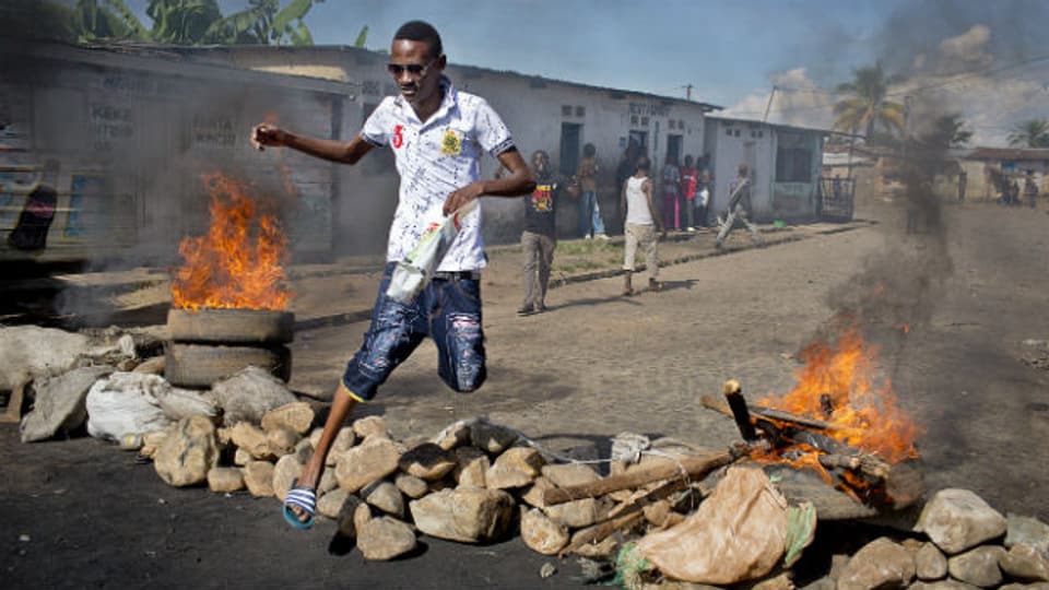 Ein Mann springt über eine brennende Barrikade in der Hauptstadt  Bujumbura.