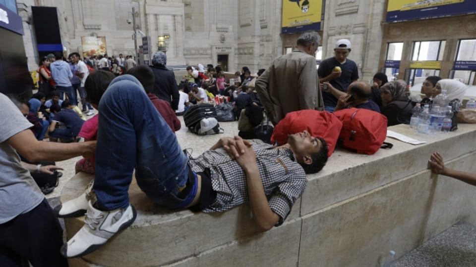 Migranten warten am Hauptbahnhof von Mailand auf die Weiterfahrt nach Norden (Juni 2014).