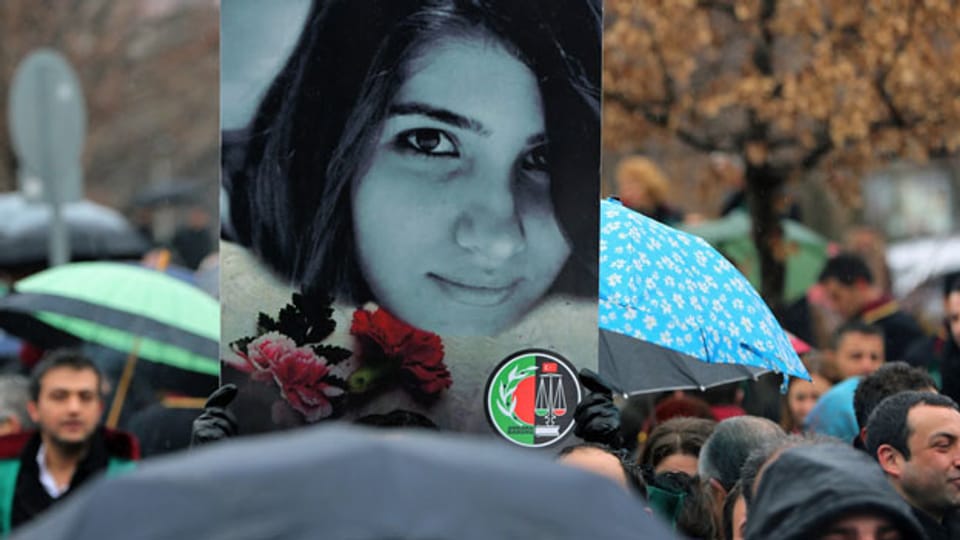 An einem Gedenkmarsch für die ermordete türkische Studentin tragen Angehörige das Portrait der jungen Frau.