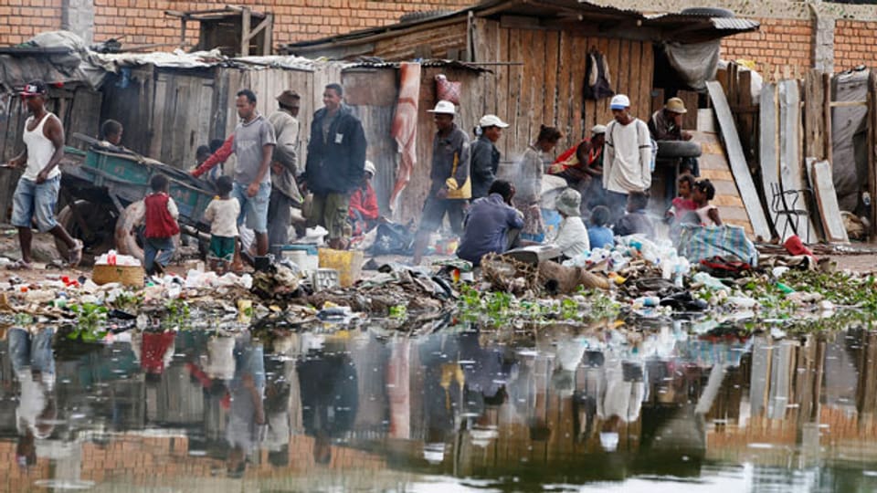 Einwohner entlang eines müllverseuchten Wasserkanals in der Stadt Antananarivo in Madagaskar.