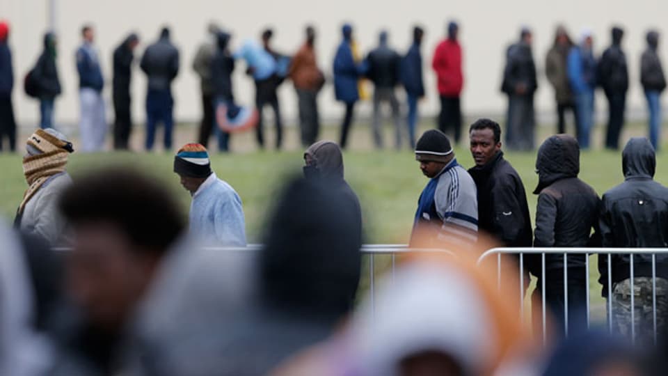 Migranten aus Afrika, Afghanistan und Syrien stehen Schlange für ein Abendessen am Jules Ferry-Tageszentrum in Calais.