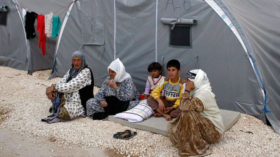 Eine syrische Flüchtlingsfamilie sitzt vor ihrem Zelt in einem türkischen Flüchtlingslager. Die Aufnahme der Flüchtlinge erfolgt auf Bitten der UNO.