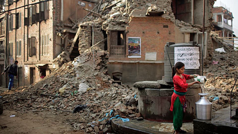 Trinkwasser holen inmitten von Trümmern. Eine Nepalesin in der Hauptstadt Kathmandu.