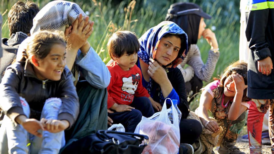 Migranten aus Afghanistan ruhen sich nach dem Überqueren der ungarisch-serbischen Grenze nahe ungarischen Stadt Asotthalom aus.