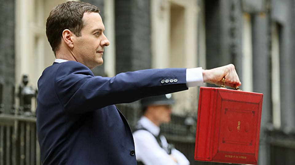 George Osborne mit seinem «Budget-Koffer». Statt tiefer Löhne, hoher Steuern und hoher Sozialzuschüsse will der neue Schatzkanzler - das Gegenteil.