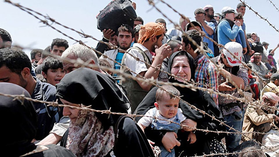 Weil sich die Situation der syrischen Flüchtlinge in den Nachbarländern zunehmend verschlechtert, versuchen immer mehr von ihnen nach Europa zu gelangen. Bild: Flüchtlinge an der syrisch-türkischen Grenze.